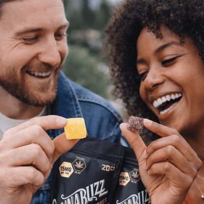 Two people holding and showing cannabis-infused gummies with a visible brand in the background.